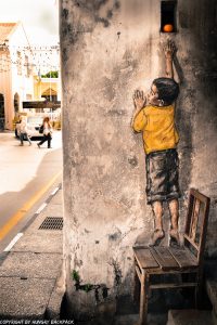 boy on chair street art mural Penang